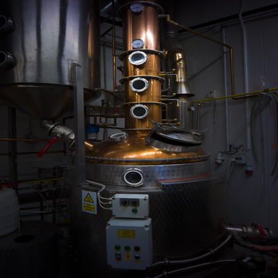 Spirit being distilled through a traditional copper pot still